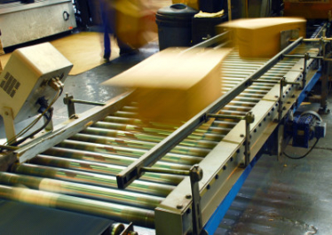 Packages being sent through a conveyer belt in a turnkey system
